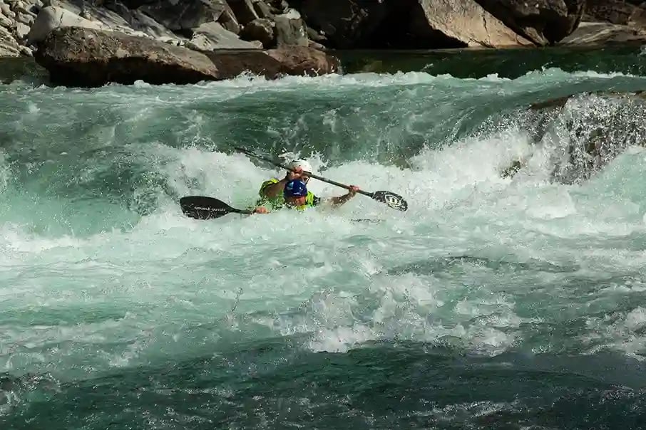 kayakers navigating a whitewater river